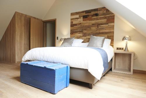 a bedroom with a large bed and a wooden wall at Koru Hôtel & Private Wellness in Autre-Église