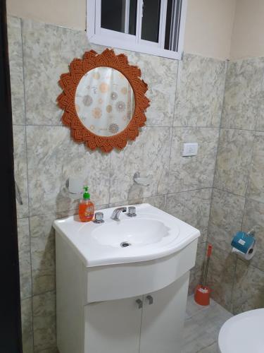 a bathroom with a white sink and a mirror at Quincho Los Abuelos in Chivilcoy