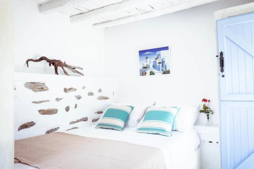 Schlafzimmer mit weißen Wänden und einem Bett mit Kissen in der Unterkunft Montana Villa in Stelida