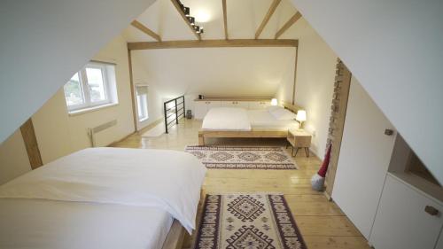 een slaapkamer op zolder met 2 bedden en een trap bij Apartman Trebevic-Sarajevo in Dovlići