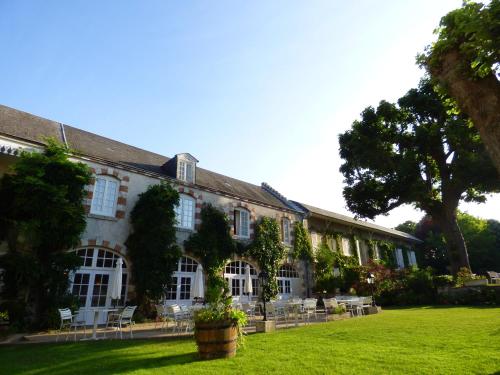 a large building with a green lawn in front of it at Hôtel La Tonnellerie in Beaugency
