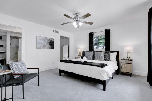 a white bedroom with a bed and a ceiling fan at Cactus Club - A Birdy Vacation Rental in San Antonio