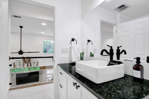 a white bathroom with a sink and a mirror at Cactus Club - A Birdy Vacation Rental in San Antonio