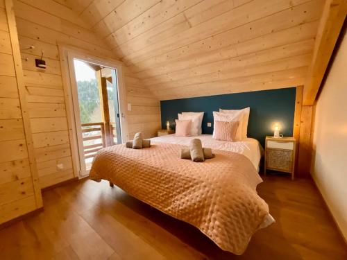 1 dormitorio con 2 camas en una habitación con paredes de madera en Chalet 2 marmottes Bain Nordique, en Gerbépal