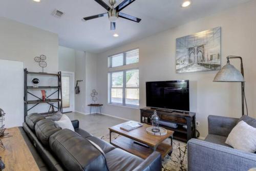a living room with a couch and a flat screen tv at Bridge - A Birdy Vacation Rental in San Antonio