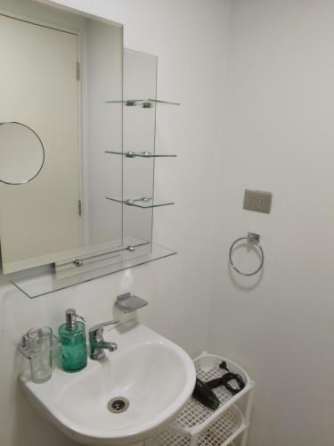 a bathroom with a white sink and a mirror at Departamento Single in Los Ángeles