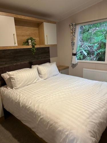 a bedroom with a white bed and a window at White Cross Bay Deer View in Windermere