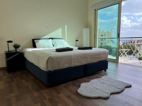 sypialnia z dużym łóżkiem i balkonem w obiekcie Coastal Elegance Maisonette w mieście Limassol