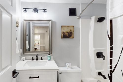 ein weißes Badezimmer mit einem Waschbecken und einem Spiegel in der Unterkunft Paradise Peak Retreat in Sugar Mountain