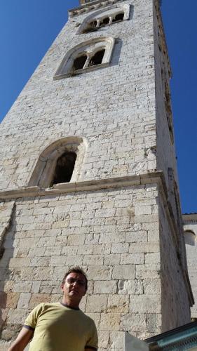 a man standing in front of a tall tower at B&B Il Campanile in Barletta