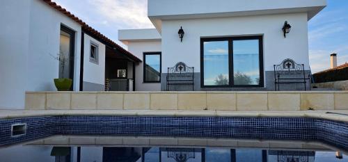 a white house with a swimming pool in front of it at Casa do Pote in Campo Maior