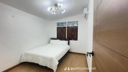a bedroom with a bed and a window and a door at Pharungruang House Thatphanom Nakonphanom พารุ่งเรืองเฮ้าส์ in That Phanom