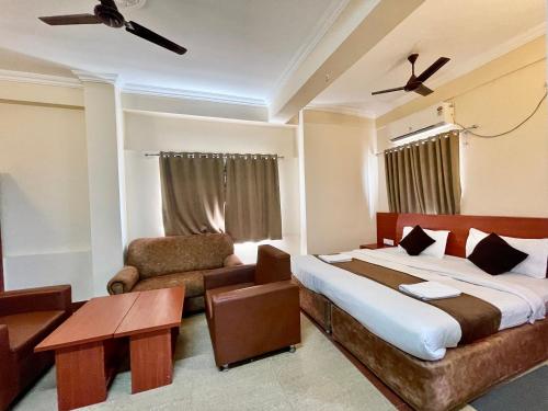 Hotel Subham Beach inn ! PURI near-sea-beach-and-temple fully-air-conditioned-hotel with-lift-and-parking-facility في بوري: غرفة نوم بسرير واريكة وكرسي