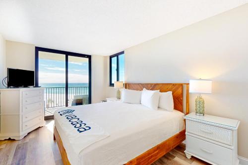 a bedroom with a bed with a view of the ocean at Sunbird #408E in Panama City Beach