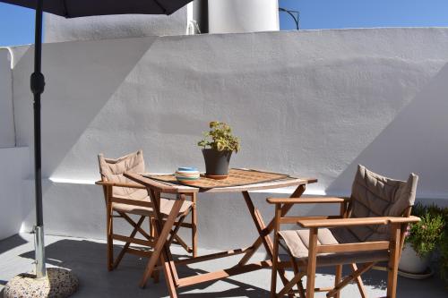 une table et des chaises avec une plante en pot sur une terrasse dans l'établissement Chora Cozy Studios, à Kythnos