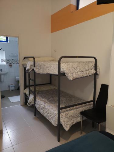 two bunk beds in a room with a chair at Hostel de las Facultades in Santander