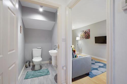 a bathroom with a toilet and a tv in it at Comfortable stylish Townhouse in Ashford sleeps 5 Netflix 2 Parking spaces Perfect for Contractors and Families in Ashford