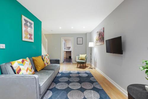 a living room with a couch and a tv at Comfortable stylish Townhouse in Ashford sleeps 5 Netflix 2 Parking spaces Perfect for Contractors and Families in Ashford