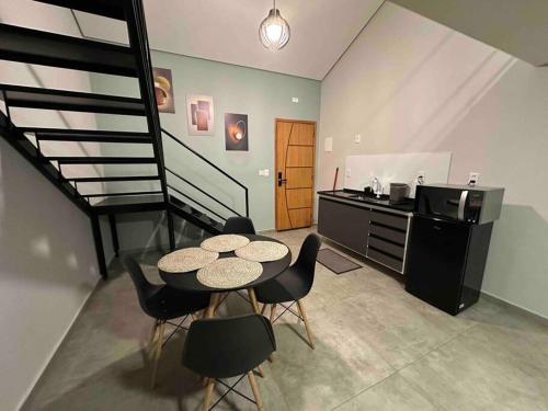 a kitchen with a table and chairs and a staircase at Apartamento/Loft 06 em Cabo Frio in Cabo Frio