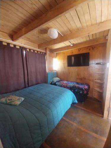 1 dormitorio con 1 cama azul en una cabaña en Casa Campo Mar Mirasol en Algarrobo