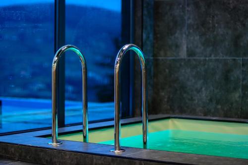 two metal faucets on a sink in a bathroom at Севеней Готель in Bukovel