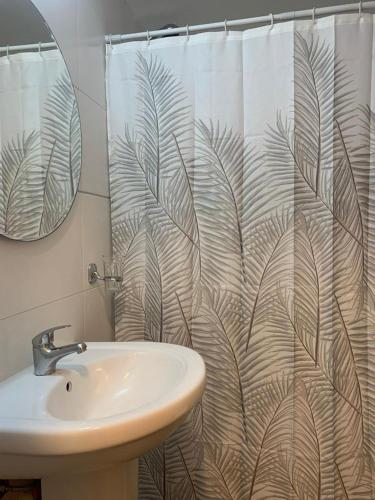 y baño con cortina de ducha y lavamanos. en Completo Monoambiente de Montevideo Bliss en Montevideo