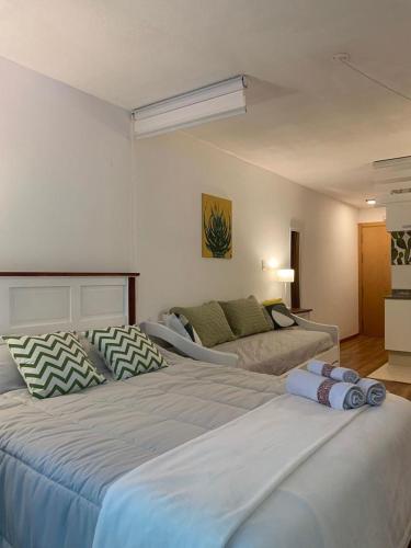 a bedroom with a large bed and a couch at Completo Monoambiente de Montevideo Bliss in Montevideo