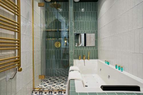 a bathroom with a bath tub and a shower at Séjours Parisiens - Suites Haussmann, Malesherbes & Madeleine in Paris