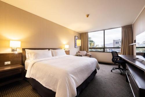 a hotel room with a large bed and a desk at Holiday Inn Express - Iquique by IHG in Iquique