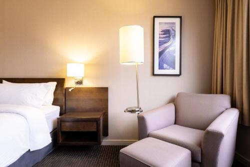 a hotel room with a bed and a chair at Holiday Inn Express - Iquique by IHG in Iquique