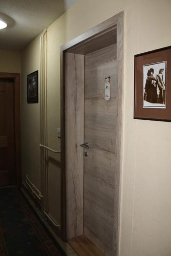 a wooden door in a hallway with a picture on the wall at Apartma Jurček Rogla in Rakovec