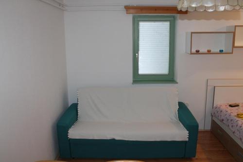 a room with a green chair and a window at Apartma Jurček Rogla in Rakovec