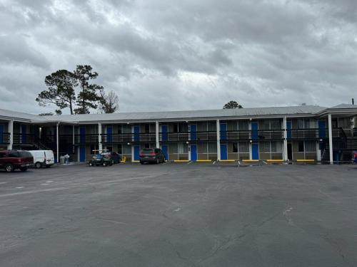 a large building with cars parked in a parking lot at Midtown Lodge in Jacksonville