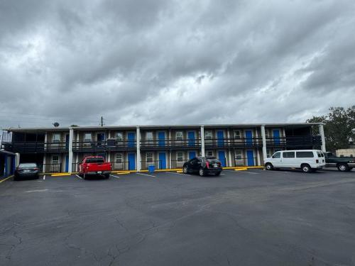 a large building with cars parked in a parking lot at Midtown Lodge in Jacksonville