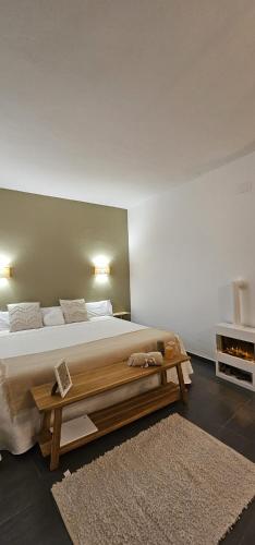 a bedroom with a large bed and a wooden bench at Villa Morena in Finestrat