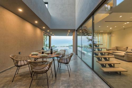 a dining room with a table and chairs and a couch at Luxury Villa Mon I Vassilikos in Vasilikos