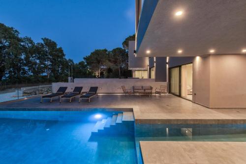 a house with a swimming pool next to a house at Luxury Villa Mon I Vassilikos in Vasilikos