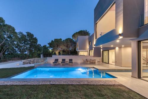 a swimming pool in the backyard of a house at Luxury Villa Mon I Vassilikos in Vasilikos