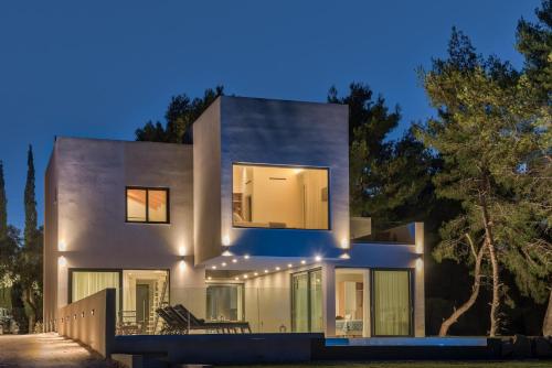 a modern house with lights on it at night at Luxury Villa Mon I Vassilikos in Vasilikos