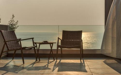 two chairs and a table in front of a window at Luxury Villa Mon I Vassilikos in Vasilikos