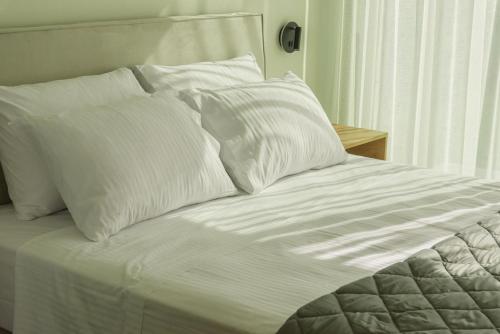 a white bed with white pillows on it at Luxury Villa Mon I Vassilikos in Vasilikos