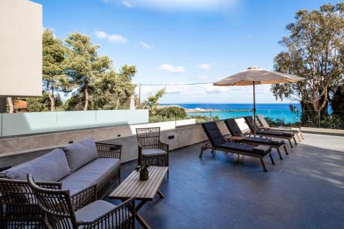 a patio with chairs and a couch and an umbrella at Luxury Villa Mon II Vassilikos in Vasilikos