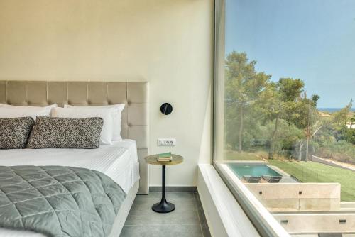 a bedroom with a bed and a large window at Luxury Villa Mon II Vassilikos in Vasilikos