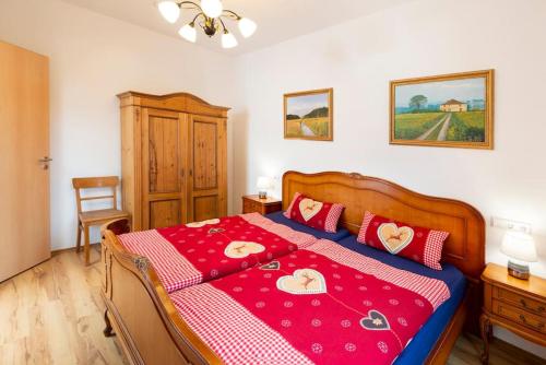 ein Schlafzimmer mit einem großen Bett mit einer roten Decke in der Unterkunft Ferienhof Obertor in Kirchberg an der Murr