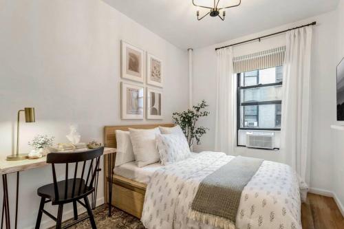 um quarto com uma cama, uma secretária e uma janela em Bright Designer Cottage in Historic Harlem em Nova York