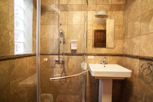 a bathroom with a sink and a shower at Baanpong Lodge in San Kamphaeng