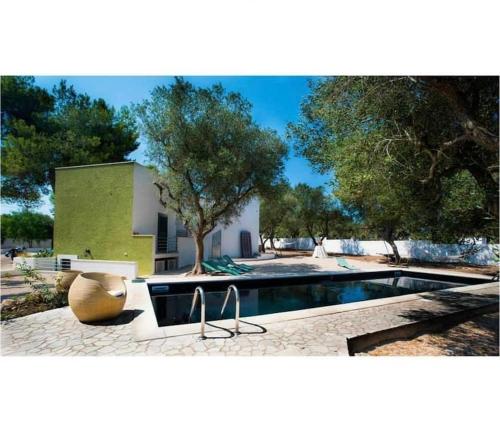 a swimming pool in front of a house with a tree at LUXURY COUNTRY VILLA CON PISCINA MARE BANDIERA BLU in Maruggio