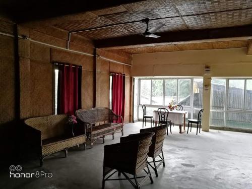 a room with a table and chairs and a dining room at Ashrayaa Prakreeti. in Jorhāt