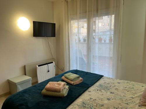 a bedroom with a bed with two towels on it at Còmode apartament al bell mig de Girona in Girona