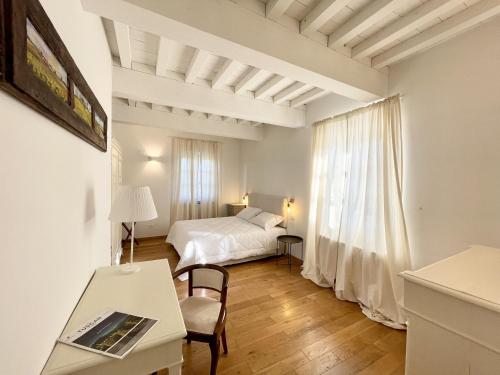 1 dormitorio con cama, escritorio y mesa con ordenador portátil en Agriturismo Antica Corte, en Valiano